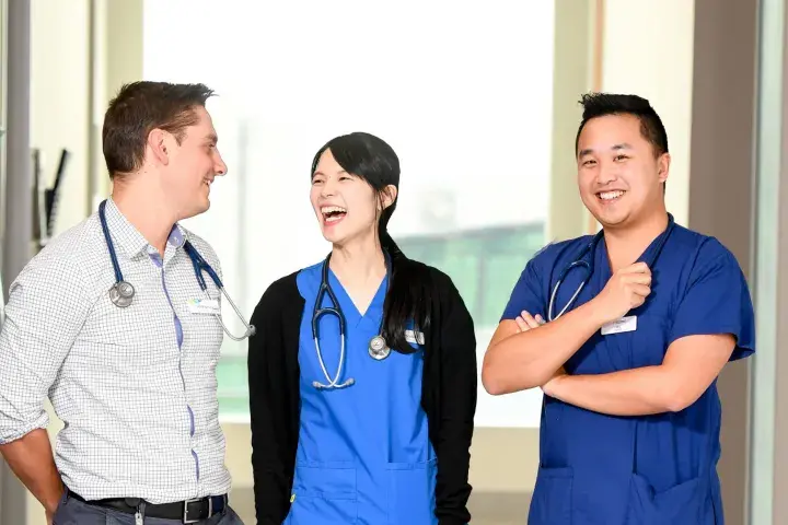 Three Western Health doctors smiling inside a hospital setting.